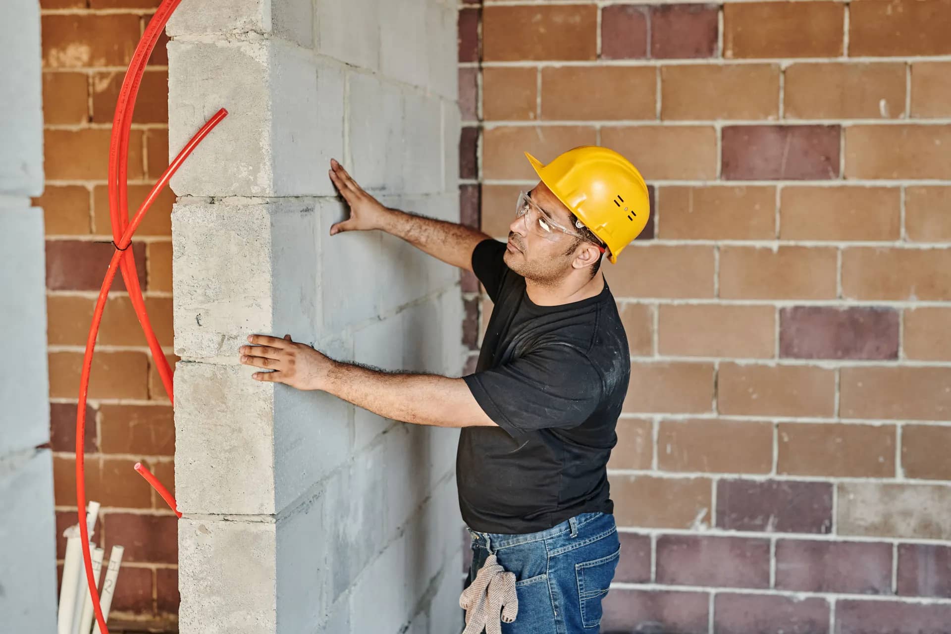 Mason checking a newly built concrete block wall