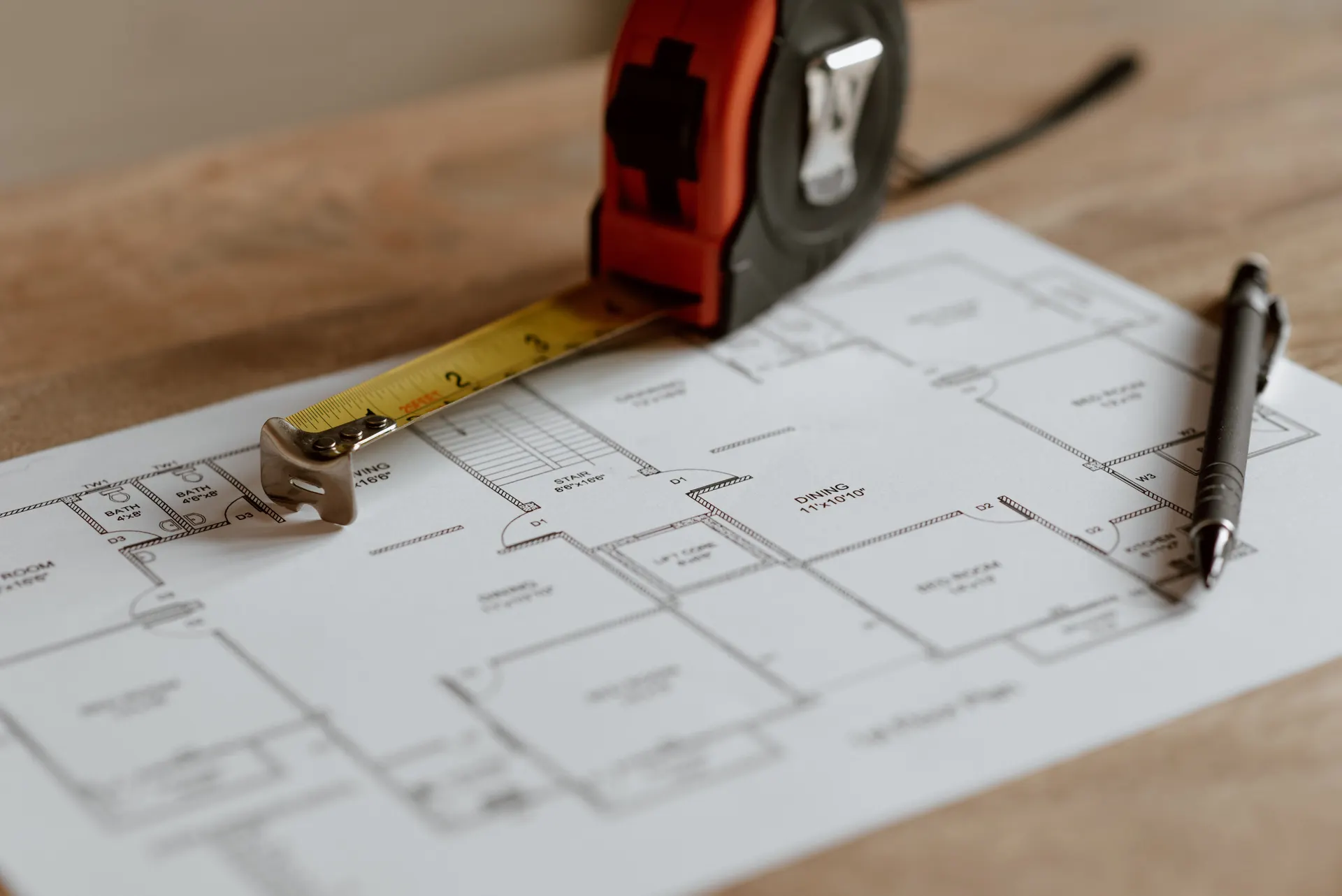 Floor plan drawing with a tape measure and pen, ready for a site survey